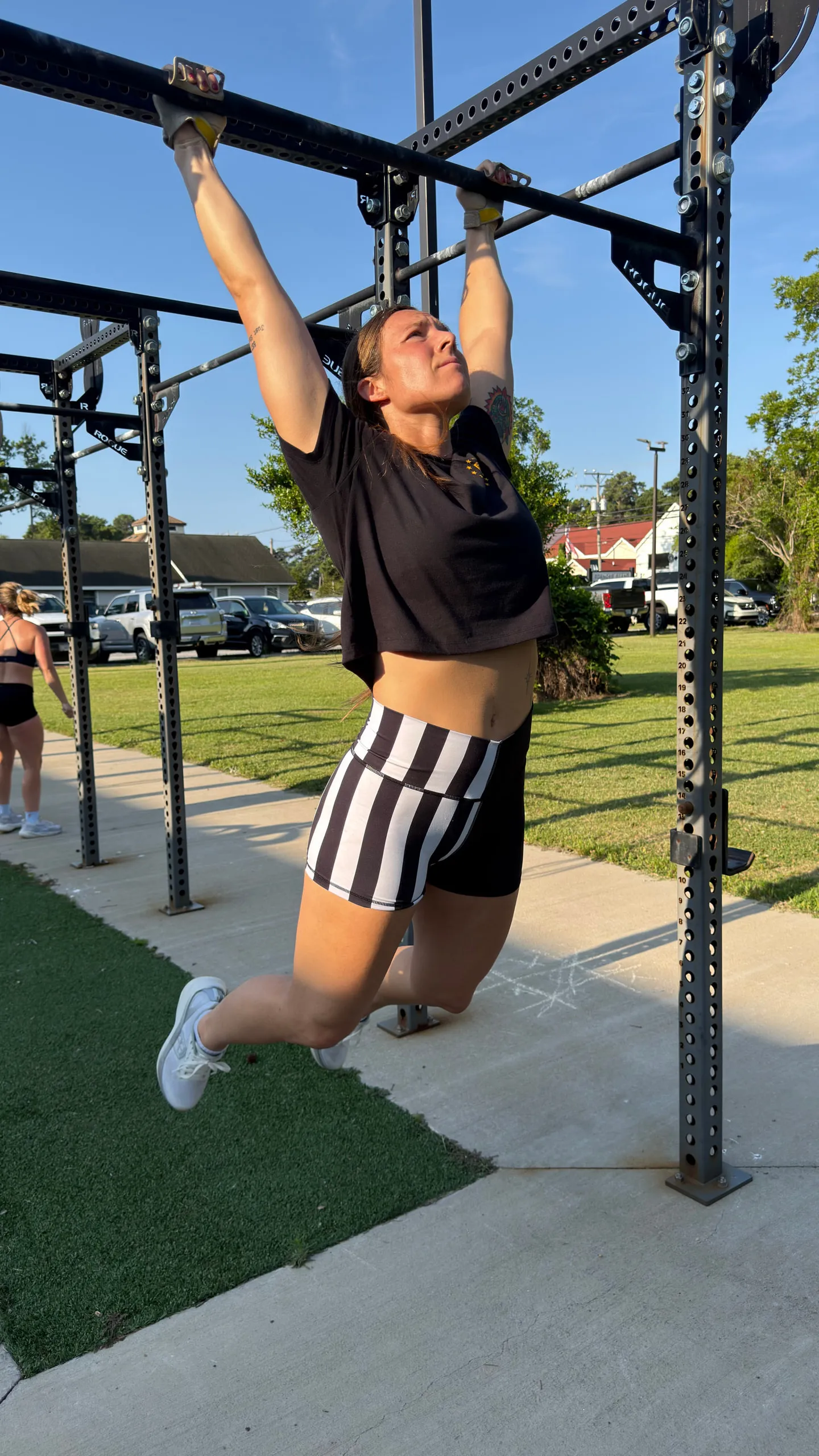 Lexi mid-set on an outdoor rig, training alongside someone else
